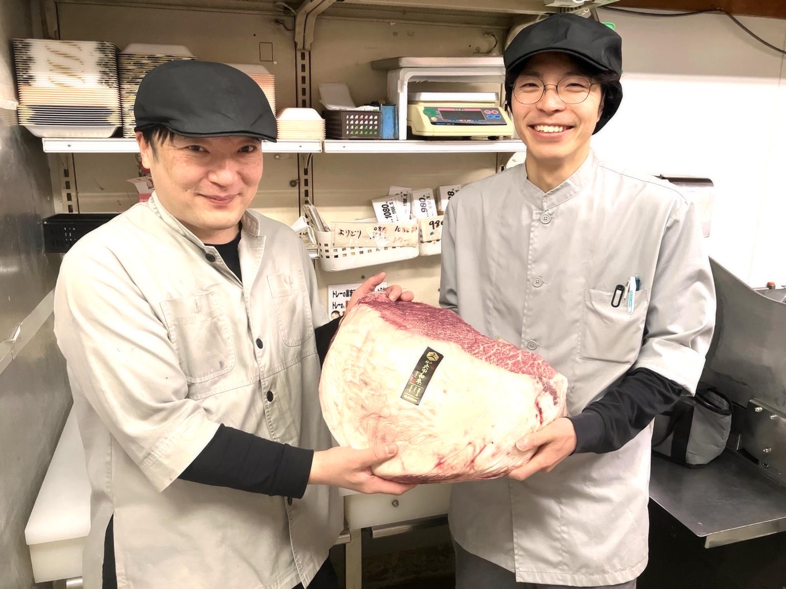 精肉を持って笑顔で並ぶ2人の職人